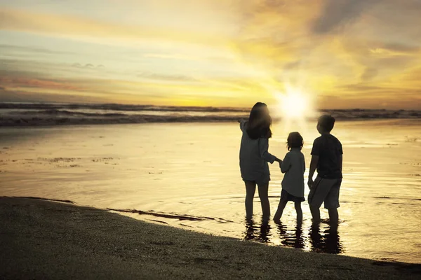 Bambini e madre in piedi sulla costa — Foto Stock