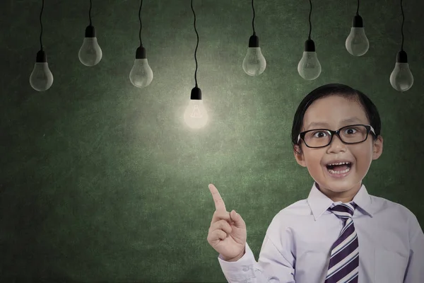 Elementary student with light bulbs — Stock Photo, Image