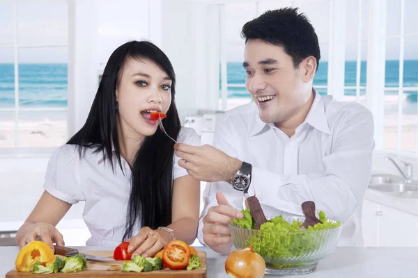 幸せなカップルが家でサラダを食べる — ストック写真