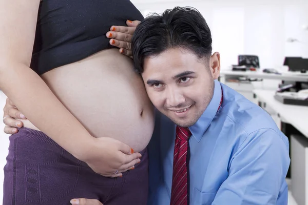 幸福的丈夫听力孕妇的肚子 — 图库照片
