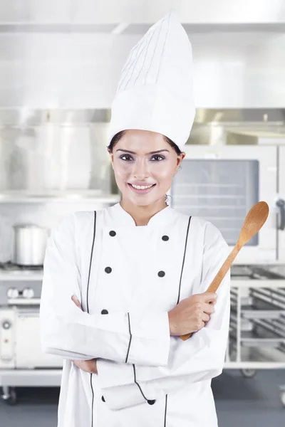 Chef indio sosteniendo cuchara de madera en la cocina —  Fotos de Stock