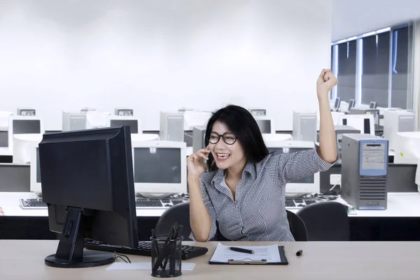 Successful businesswoman with computer and mobile phone — Stock Photo, Image