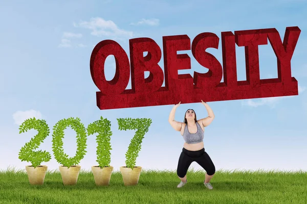 Vrouw opheffing van obesitas woord — Stockfoto