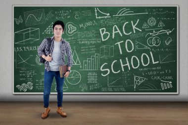 Asyalı erkek öğrenci sınıfta ayakta