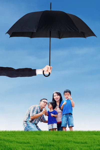 Familie zeepbel spelen op veld onder paraplu — Stockfoto