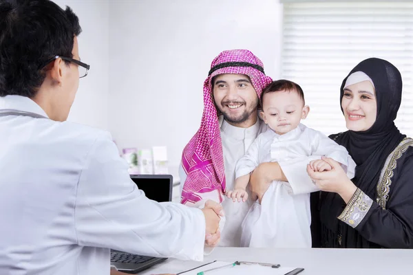 Familia estrechando la mano con pediatra en la clínica —  Fotos de Stock
