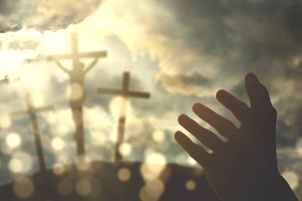 Hands of a Christian man with three crucifixes