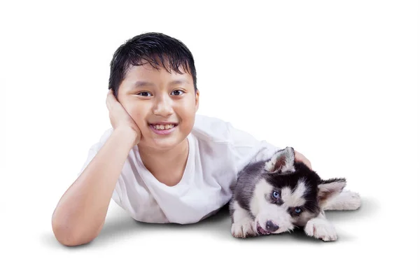 Chlapeček si hraje s husky štěně na studio — Stock fotografie