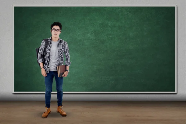 Male student standing near the chalkboard — Stock Photo, Image