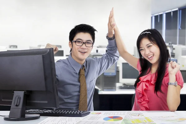 Successful workers clapping hands in the workplace — Stock Photo, Image