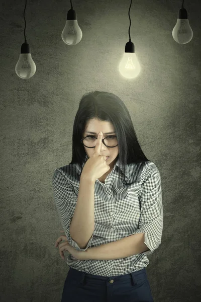 Doordachte zakenvrouw met een heldere lamp — Stockfoto