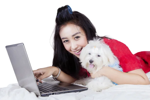 Mulher com cão usando um laptop no estúdio — Fotografia de Stock