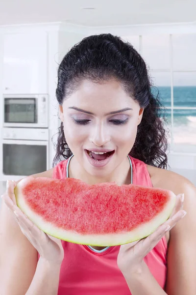 Junge Frau sieht glücklich mit Wassermelone aus — Stockfoto