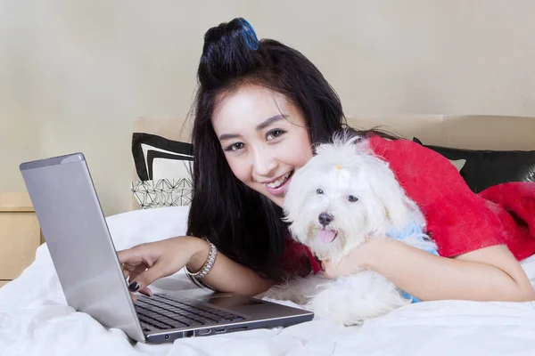 Jovem mulher usando um laptop com cão maltês — Fotografia de Stock
