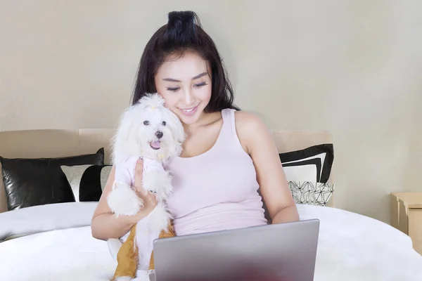 Hermosa mujer con perro en la cama —  Fotos de Stock