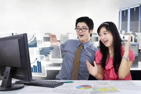 Mensen uit het bedrijfsleven met virtuele grafieken in het kantoor — Stockfoto
