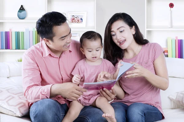 Familie lezen van een boek in de woonkamer — Stockfoto
