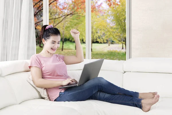 Young woman raising hand on the couch