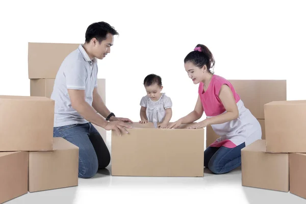 Asiatisk familj packning kartong på studio — Stockfoto