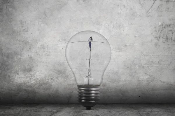 Businesswoman walking inside light bulb — Stock Photo, Image