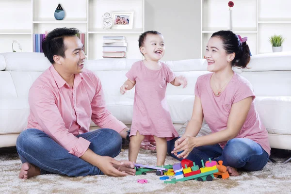 Família alegre com brinquedos na sala de estar — Fotografia de Stock