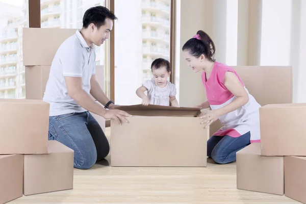 La famille déballe le carton près de la fenêtre — Photo