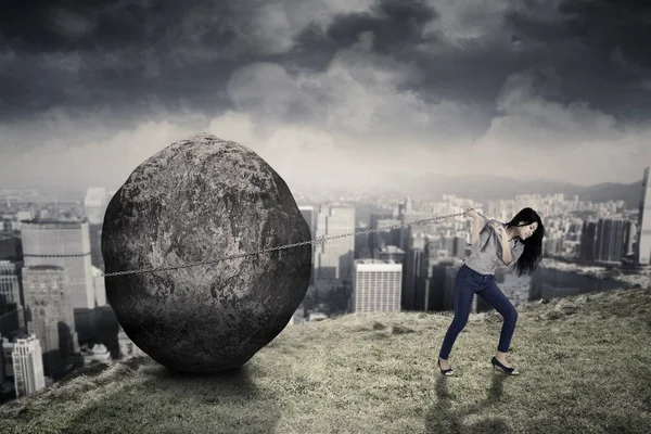 Vrouwelijke ondernemer met een grote steen op de heuvel — Stockfoto