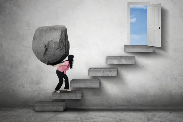 Mujer fuerte con piedra en las escaleras —  Fotos de Stock