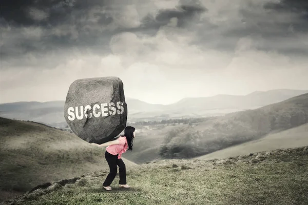 Woman brings boulder with success word — Stock Photo, Image