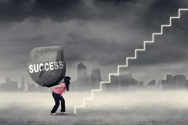 Woman brings stone and climbing stairs — Stock Photo, Image