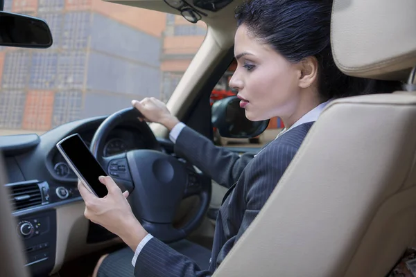 Mujer usando el teléfono celular mientras conduce el coche — Foto de Stock
