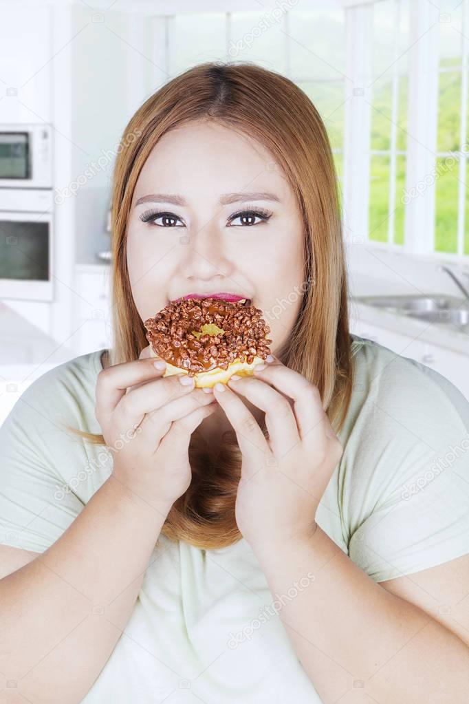 Young woman eats donut 