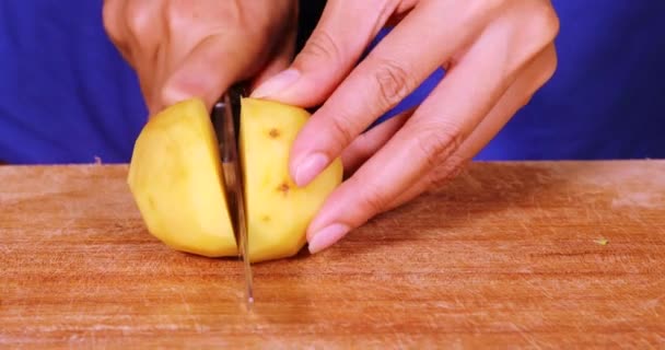 Женские руки режут картофель — стоковое видео