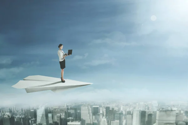 Businesswoman with laptop on paper plane — Stock Photo, Image