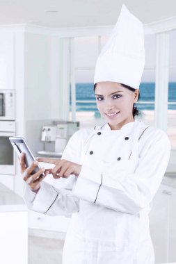 Bayan baker mutfakta cep telefonu kullanarak