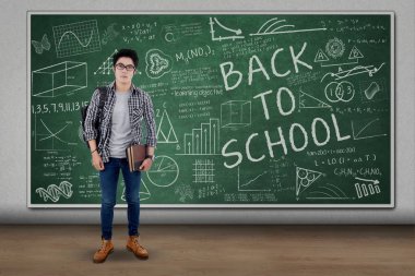 Erkek öğrenci sınıfta kara tahta ile