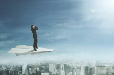 Kağıt uçağı üzerinde dürbün olan adam