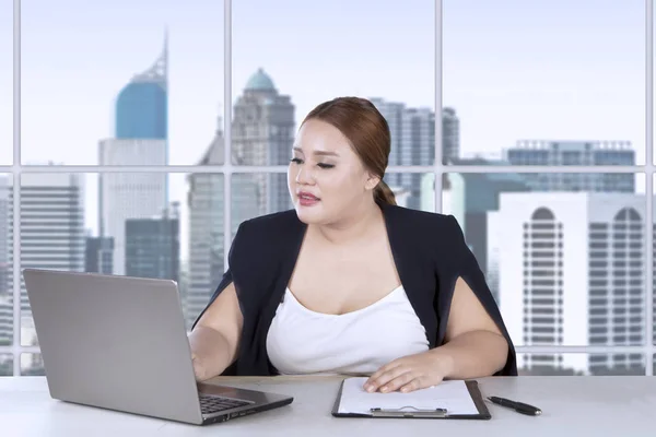 Товста жінка працює на ноутбуці та кишені — стокове фото