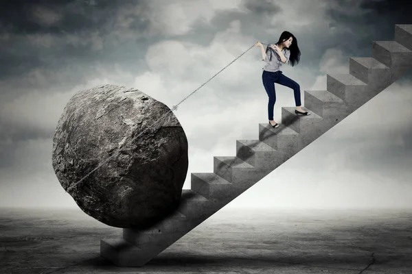 Empreendedora feminina carregando grande pedra na escada — Fotografia de Stock