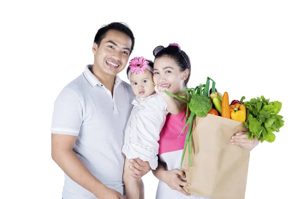 Família feliz detém legumes no estúdio — Fotografia de Stock