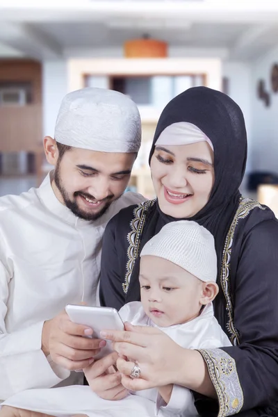 Happy parents and their child use cellphone — Stock Photo, Image