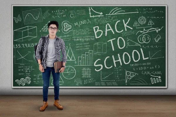Male student with chalkboard in the classroom — Stock Photo, Image