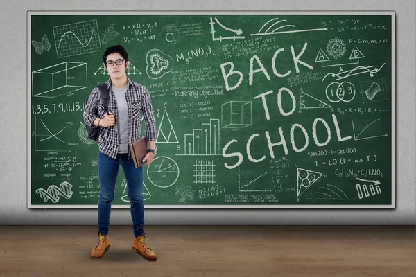 Male student with doodles on the chalkboard — Stock Photo, Image