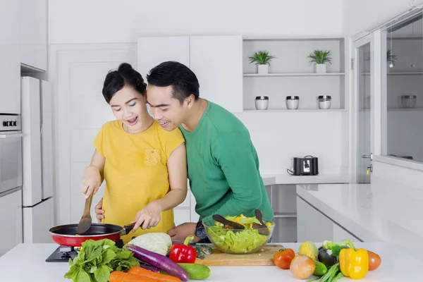 Mann sucht seine Frau beim Kochen in Küche — Stockfoto