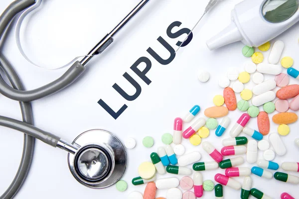 Palabra de lupus con medicamentos y estetoscopio — Foto de Stock