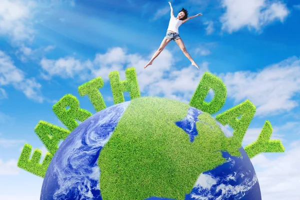Mulher salta acima do globo verde — Fotografia de Stock
