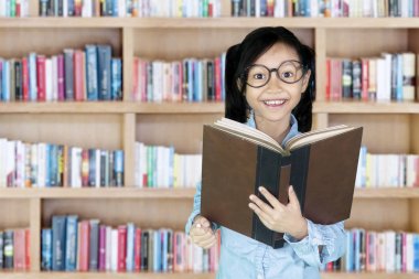 küçük kız holding kitap kütüphane 