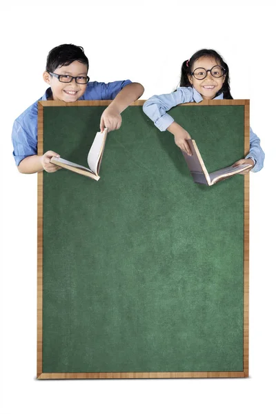 Ragazzo e ragazza in possesso di libro in studio — Foto Stock