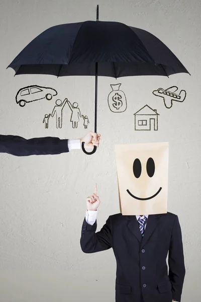 Geschäftsmann mit Pappkopf unter Regenschirm — Stockfoto