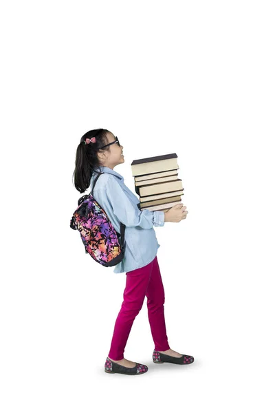 Menina carregando pilha de livros em estúdio — Fotografia de Stock
